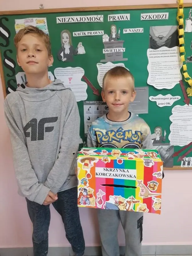 Na zdjęciu podopieczni świetlicy prezentujący Skrzynkę Korczakowską na tle "Kącika Prawnego"