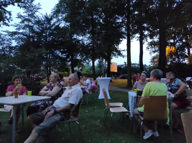 Na zdjęciu osoby siedzące przy stolikach ustawionych przy tarasie leszczyńskiego Zameczku podczas potańcówki