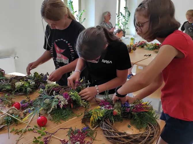 Na zdjęciu dzieci wykonujące wianki podczas warsztatów florystycznych