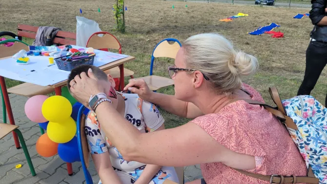 Na zdjęciu animatorka malująca twarz dziecku