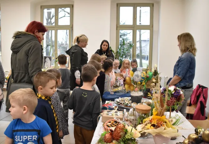 Przedszkolaki wraz z wychowawcami oglądają wystawę rękodzieła
