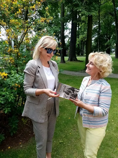 Na zdjęciu Izabela Malik, Kierowniczka Działu Pomocy Społecznej w Ośrodku Pomocy Społecznej w Czerwionce-Leszczynach, odbierająca książkę pt. "Z ziemi nieludzkiej do Polski" z rąk Walentyny Kozioł.