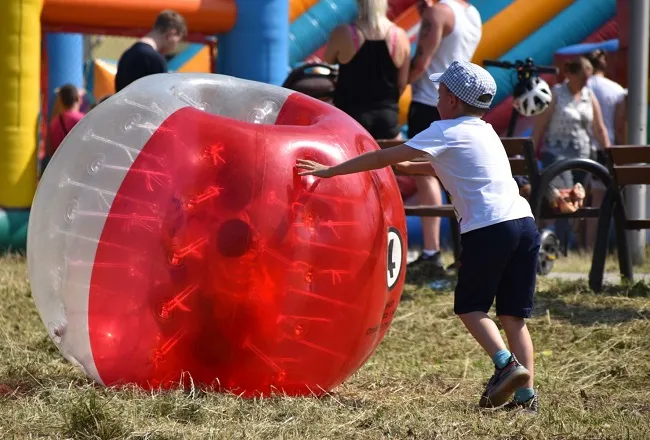 Uczestnik festynu pchający dmuchaną kulę do Bumper Ball (zdj. Katarzyna Mazur)